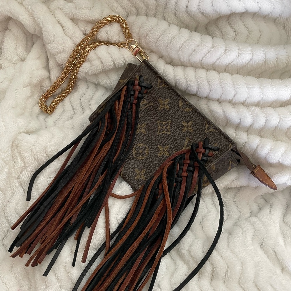 Louis Vuitton wristlet. 4.8x6.8 in size. Leather fringe black and brown.